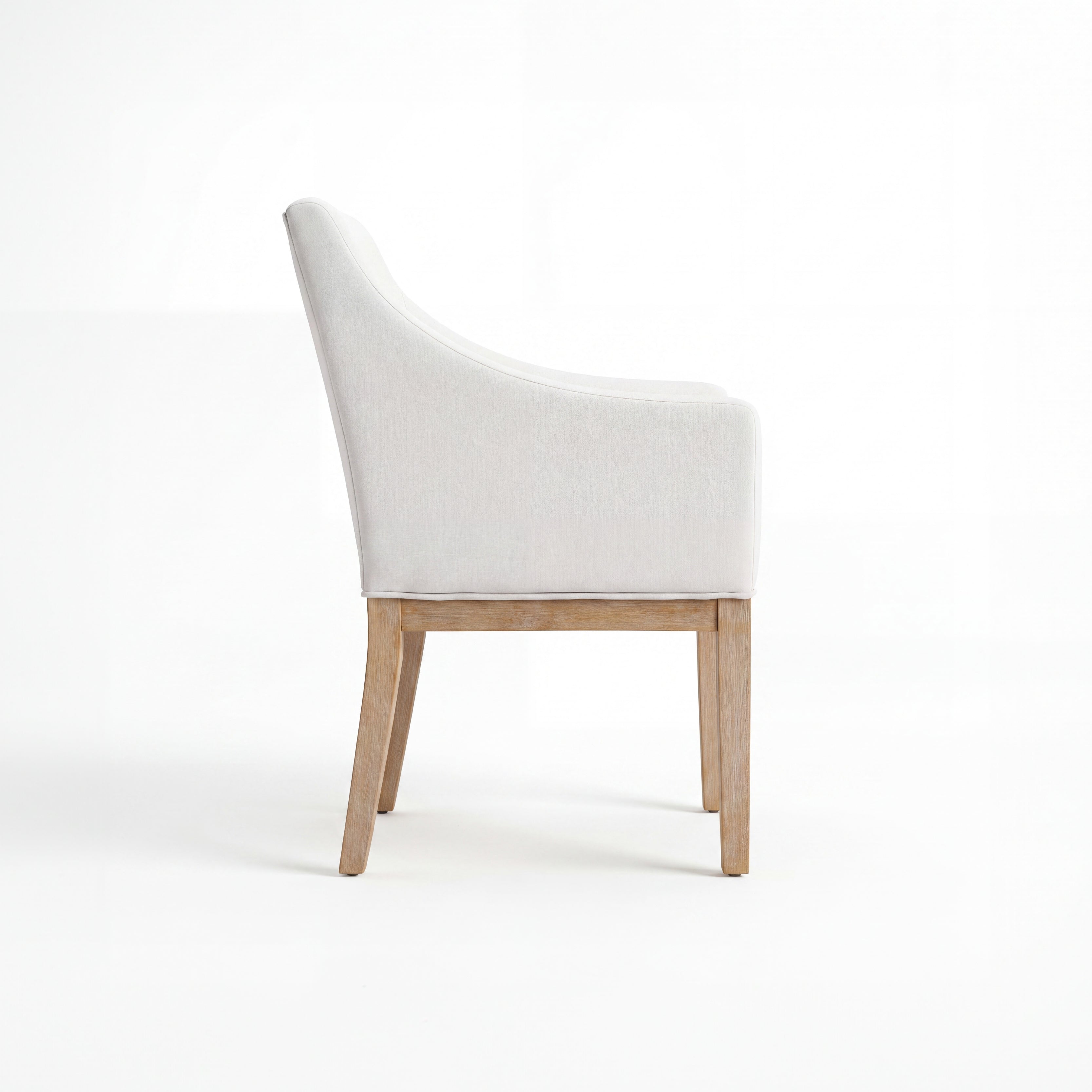 A modern dining chair with a light beige upholstered seat and curved backrest, supported by light natural wood legs, shown from a side profile on a white studio background.