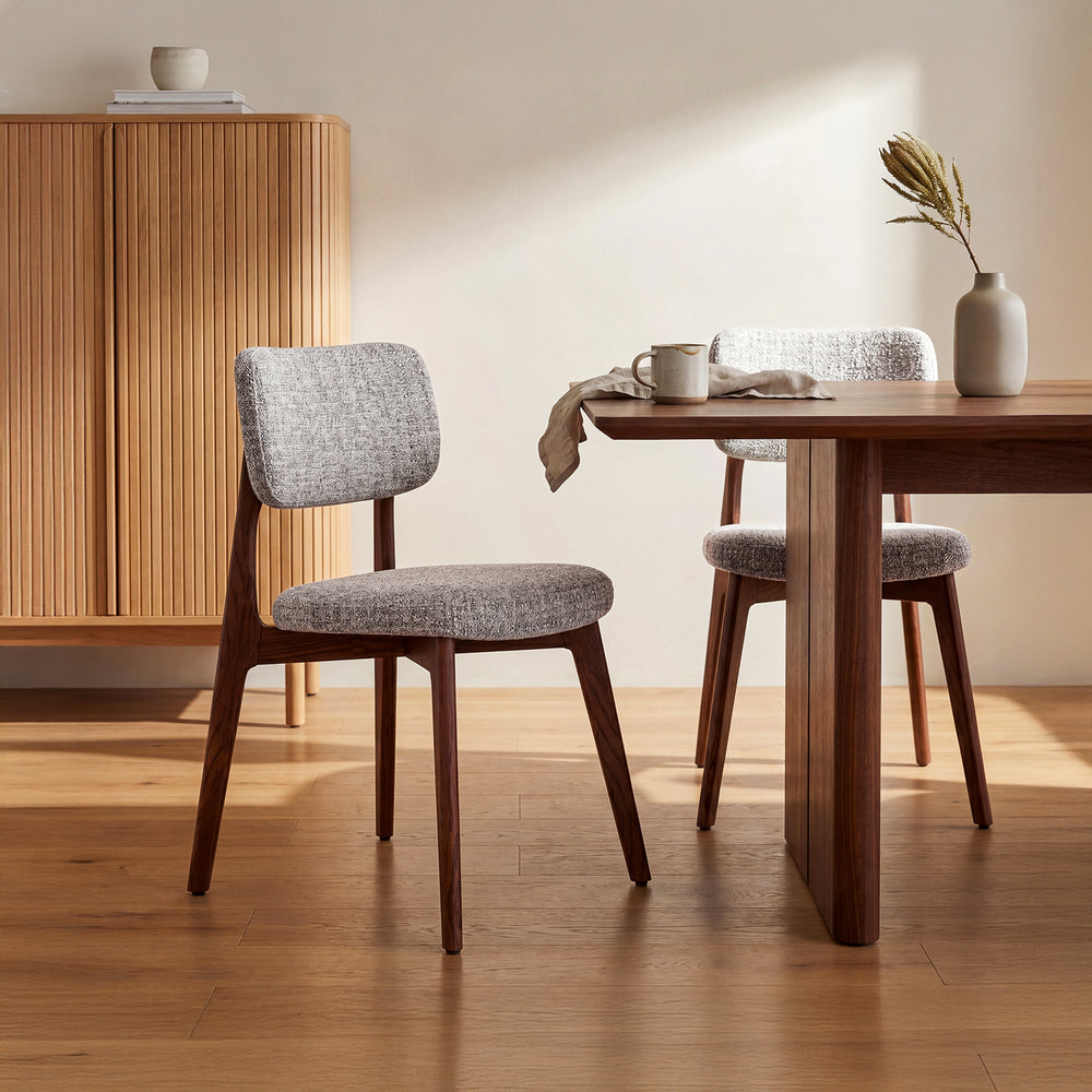 Dining room with wooden table and chairs on a wooden floor.