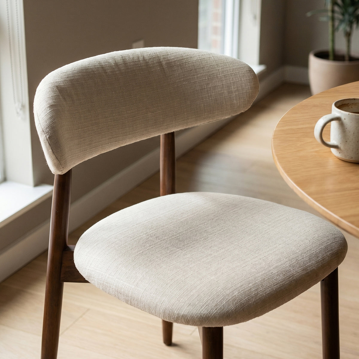 COLAMY NOYA beige upholstered dining chair with a curved backrest and padded seat